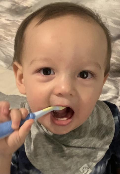 little boy with toothbrush in mouth